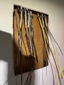 Wall opening with electrical conductors during subpanel replacement