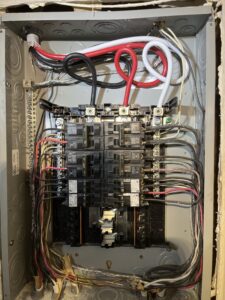 Open subpanel showing breakers and connected circuit wiring