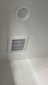 Bathroom ceiling with exhaust fan grille and recessed light