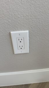 Duplex electrical outlet with wall plate in renovated apartment